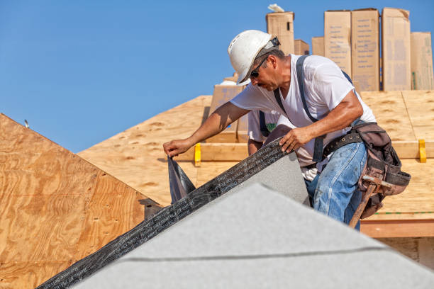 roofer tears off protective cover of underlayment on a new roof